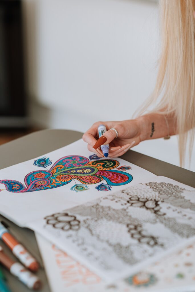 adult woman colroing in a coloring book for adults