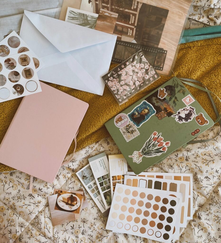 Aesthetic arrangement of notebooks, stickers, and envelopes in a cozy flat lay.